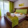 Double room, © Wiener Alpen / Christian Kremsl Room with double bed, wooden floor and green curtains