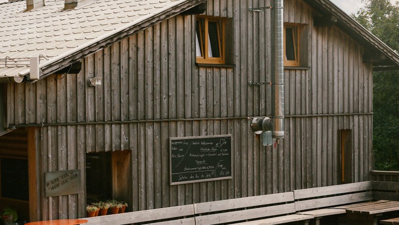 Schutzhütte Haltestelle Baumgartner, Schneeberg, Hütte, Schneebergland, Wiener Alpen in Niederösterreich, © Wiener Alpen/Sophie Menegaldo Schutzhütte Haltestelle Baumgartner mit Terrasse und Sitzbänken vor dem Holzgebäude