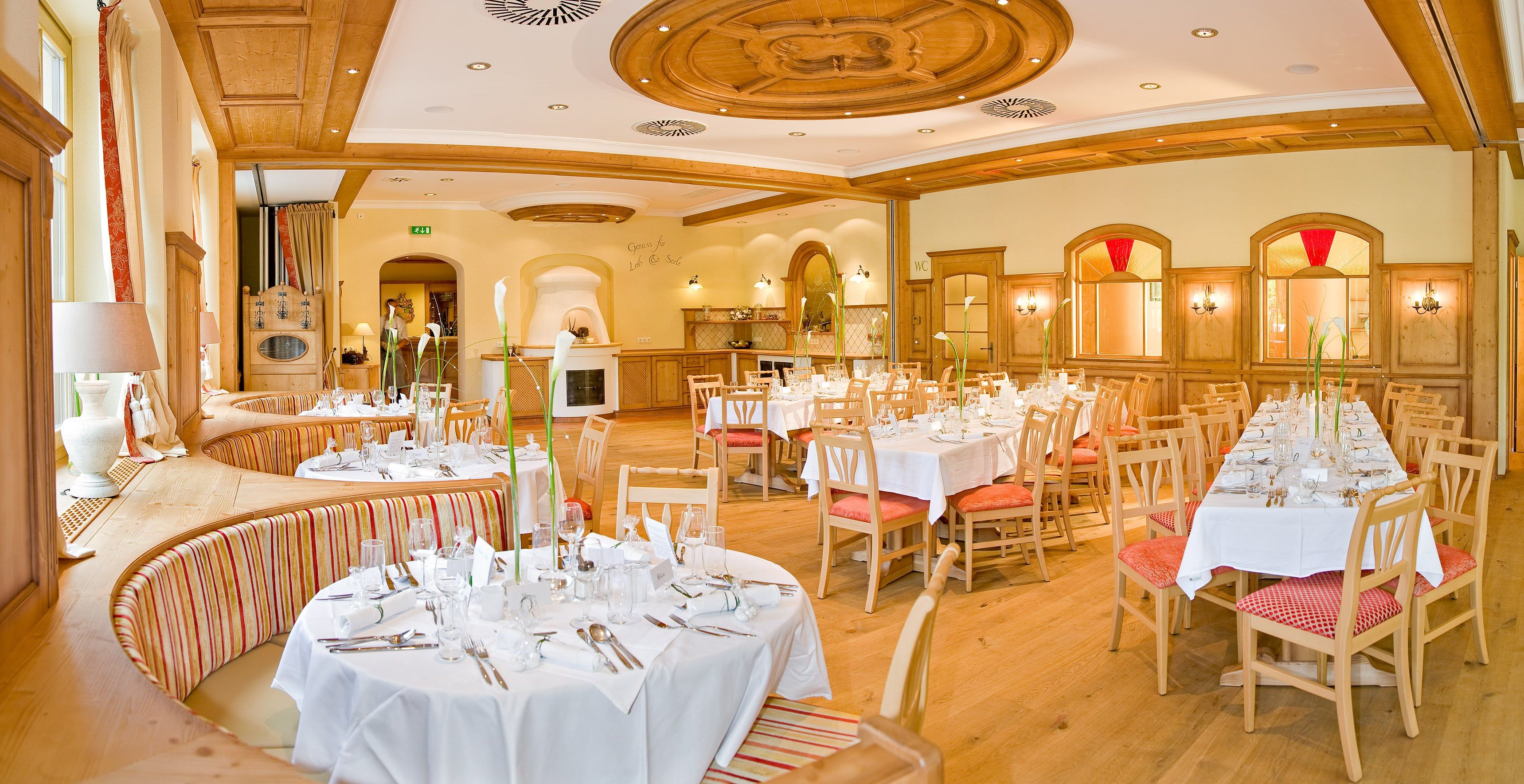 Eleganter Festsaal mit gedeckten Tischen und Holzeinrichtung.