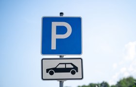 Blaues Parkzeichen mit wei&szlig;em P und darunter ein wei&szlig;es Schild mit schwarzer Auto-Silhouette