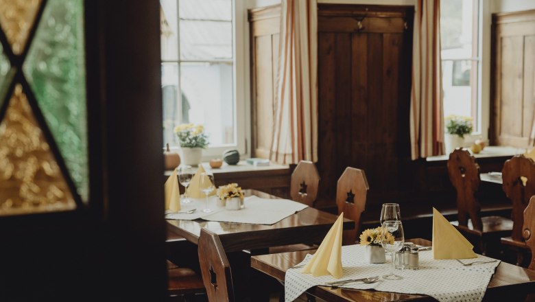 Cozy restaurant with wooden furniture and laid tables.