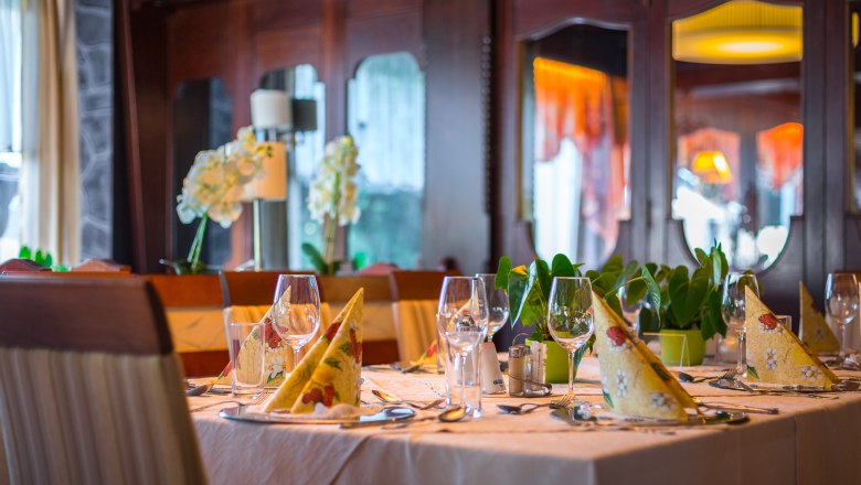 Dining room tables laid out with napkins and wine glasses.
