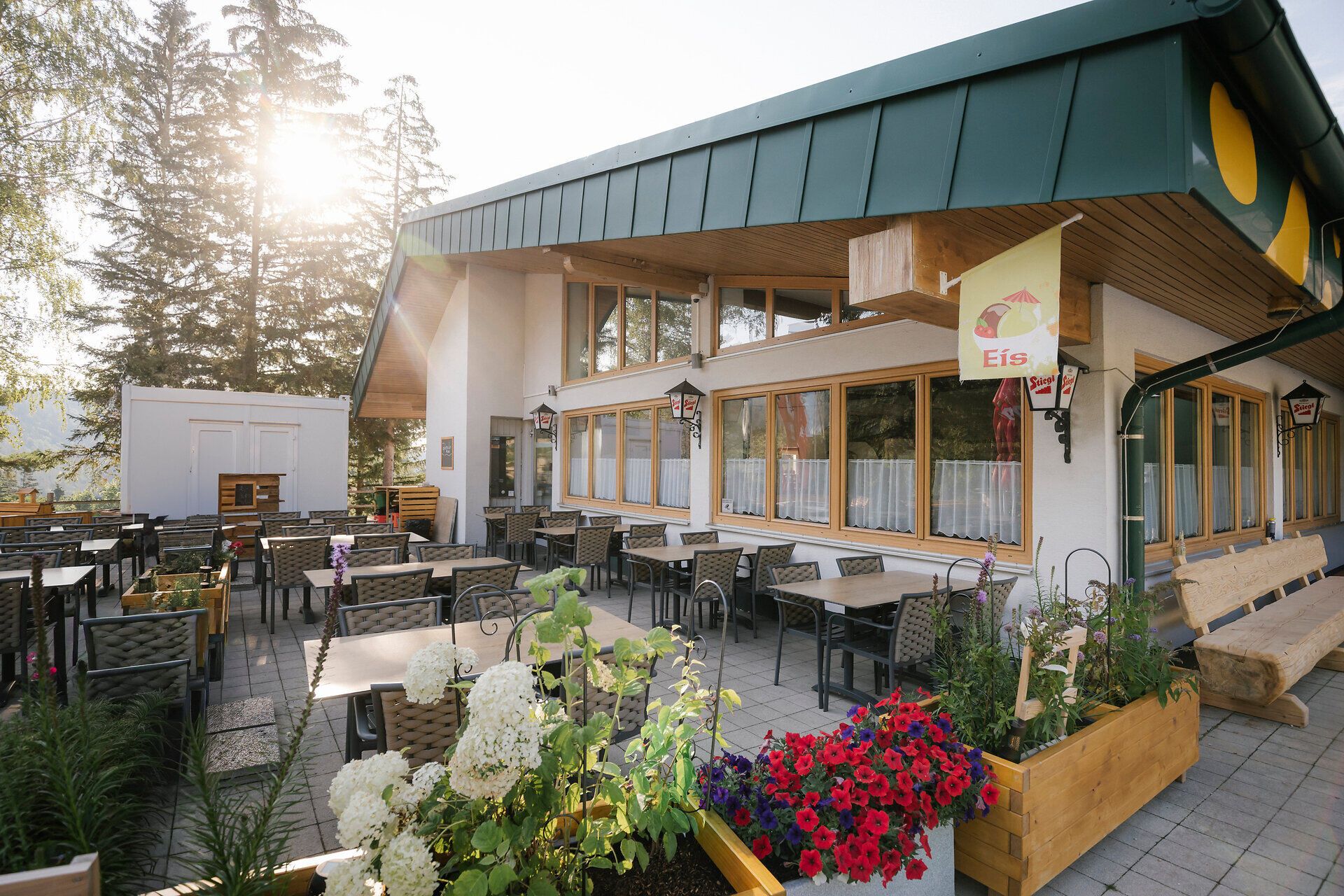 Sonnige Terrasse mit Sitzplätzen und Blumenschmuck im Lahning-Inn am Schneeberg