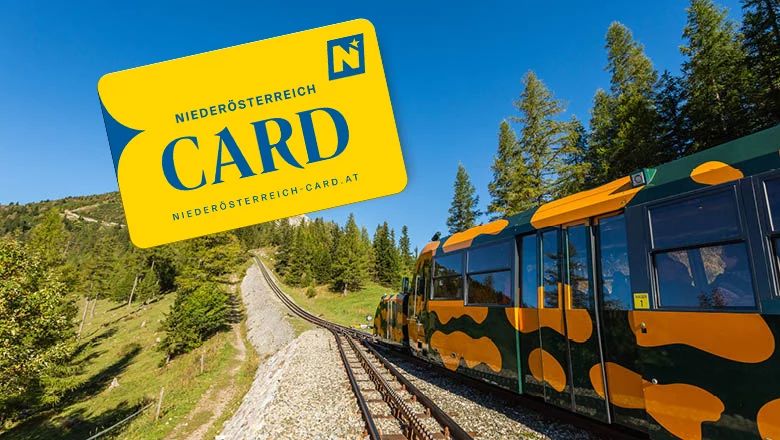 Bergbahn mit orange-schwarzem Muster auf Schienen in bewaldeter Landschaft und gelbe Karte mit Aufschrift 'NIEDERÖSTERREICH CARD'