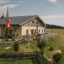 Au&szlig;enansicht des Almreserlhauses am Schneeberg mit Terrasse und Fahnenmast