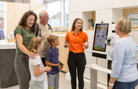 Gro&szlig;eltern, Enkelkinder und Mutter werden von Mitarbeiterin beraten