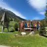 Entrance to the Forellino children's playground with mountain landscape in the background.