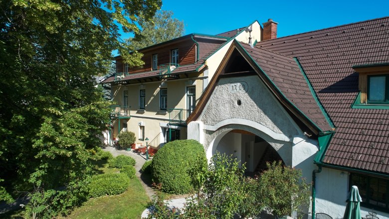 Landhaus Puchbergerhof a kerttel &eacute;s a f&aacute;kkal az előt&eacute;rben.