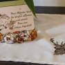 Welcome card with bird drawing and chocolates on a tablecloth with deer motif.