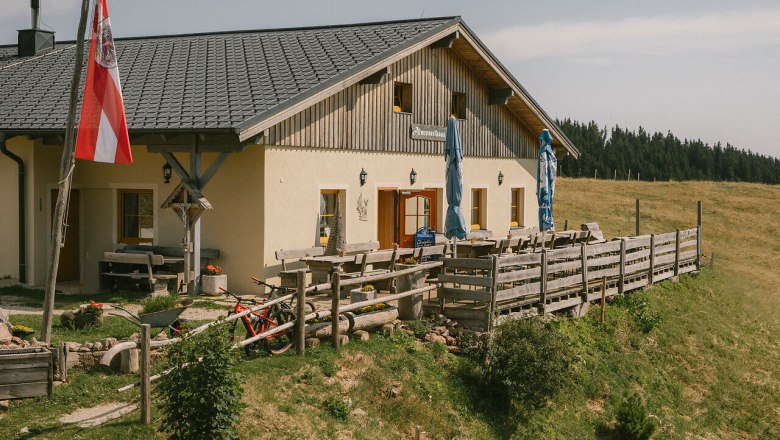 Almreserlhaus, Schneeberg, Hütte, Schneebergland, Wiener Alpen in Niederösterreich, © Wiener Alpen/Sophie Menegaldo Außenansicht des Almreserlhauses am Schneeberg mit Terrasse und Fahnenmast