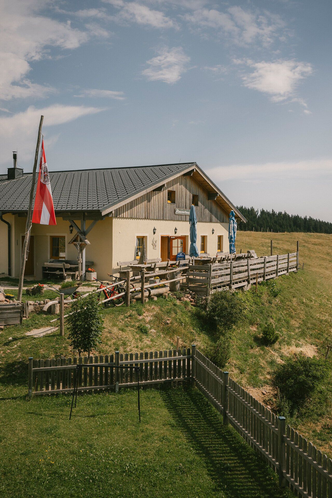 Außenansicht des Almreserlhauses am Schneeberg mit Terrasse und Fahnenmast