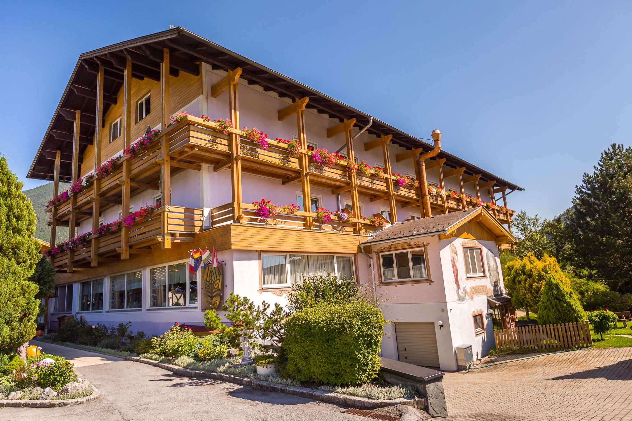 Paradiesquelle rosa Hausansicht mit Holzbalkone 