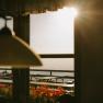 Sonnenlicht f&auml;llt durch das Fenster der Fischerh&uuml;tte am Schneeberg auf die Terrasse mit Sitzb&auml;nken