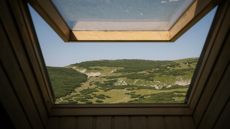 Ausblick durch ein Dachfenster auf die Berglandschaft beim Damb&ouml;ckhaus am Schneeberg