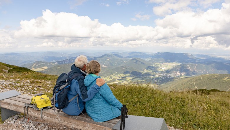 Mann und Frau sitzen auf einer Bank am  Schneeberg