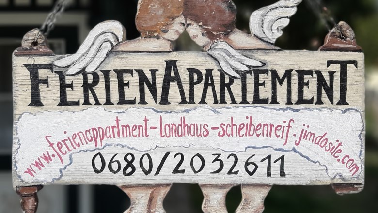 F&aacute;b&oacute;l k&eacute;sz&uuml;lt t&aacute;bla "Holiday apartment" felirattal &eacute;s k&eacute;t angyallal.