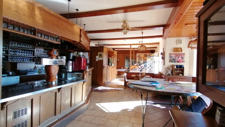 Interior view of a traditional restaurant with wooden furniture and bar.