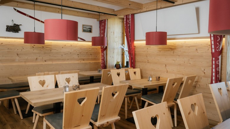 Gastraum mit Holztischen und St&uuml;hlen mit Herzmotiv im Damb&ouml;ckhaus am Schneeberg