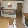 Gem&uuml;tliches Apartment mit K&uuml;che, Esstisch und Sofa.