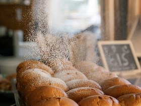 Frisch gebackene Buchteln werden mit Staubzucker bestreut