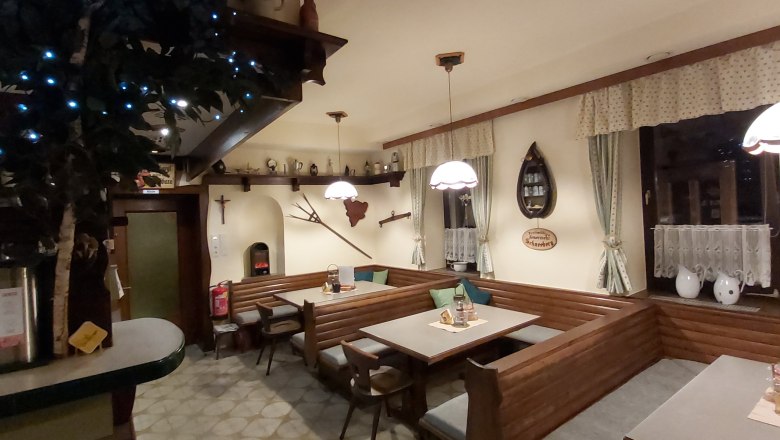 Cozy dining room with wooden furniture, decorative curtains and rustic accessories.