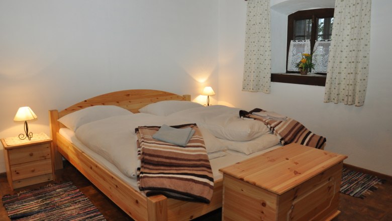 Cozy bedroom with wooden furniture and double bed.
