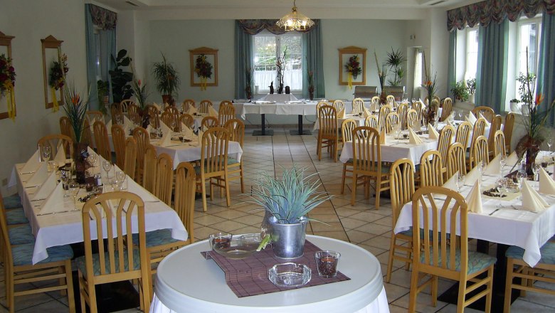 Elegant dining room with laid tables and wooden chairs.
