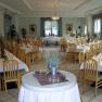 Eleganter Speisesaal mit gedeckten Tischen und Holzst&uuml;hlen.