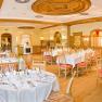 Eleganter Festsaal mit gedeckten Tischen und Holzeinrichtung.
